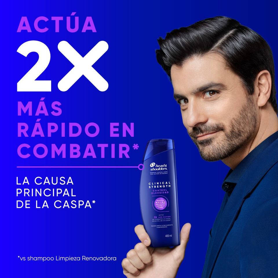 Hombre con cabello oscuro y camisa negra sobre fondo azul, con texto "Actúa 2X Más Rápido en Combatir* la Causa Principal de la Caspa"