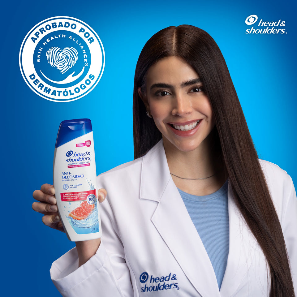 Dermatóloga con la botella de Head & Shoulders Anti-Oleosidad y el sello aprobado por dermatólogos del Skin Health Alliance